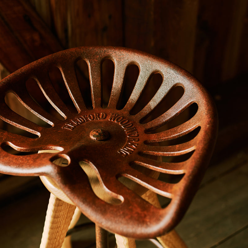 Close-up of Bradford Woodworking cast iron tractor seat, custom-cast at an Amish foundry in Lancaster County PA