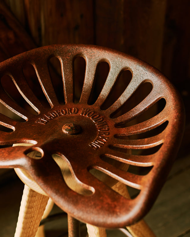 Close-up of Bradford Woodworking cast iron tractor seat, custom-cast at an Amish foundry in Lancaster County PA