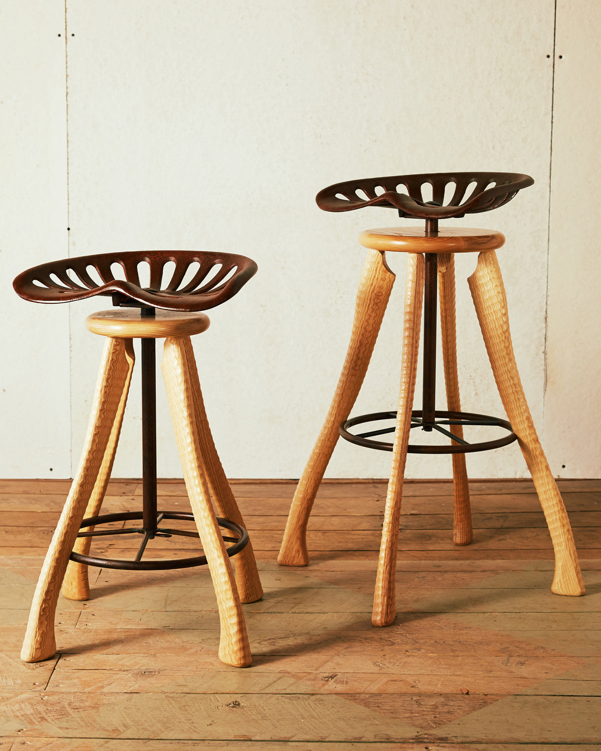 Handmade farmhouse tractor seat counter stool and bar stool with cast iron seats and ax handle ash legs, Bradford Woodworking