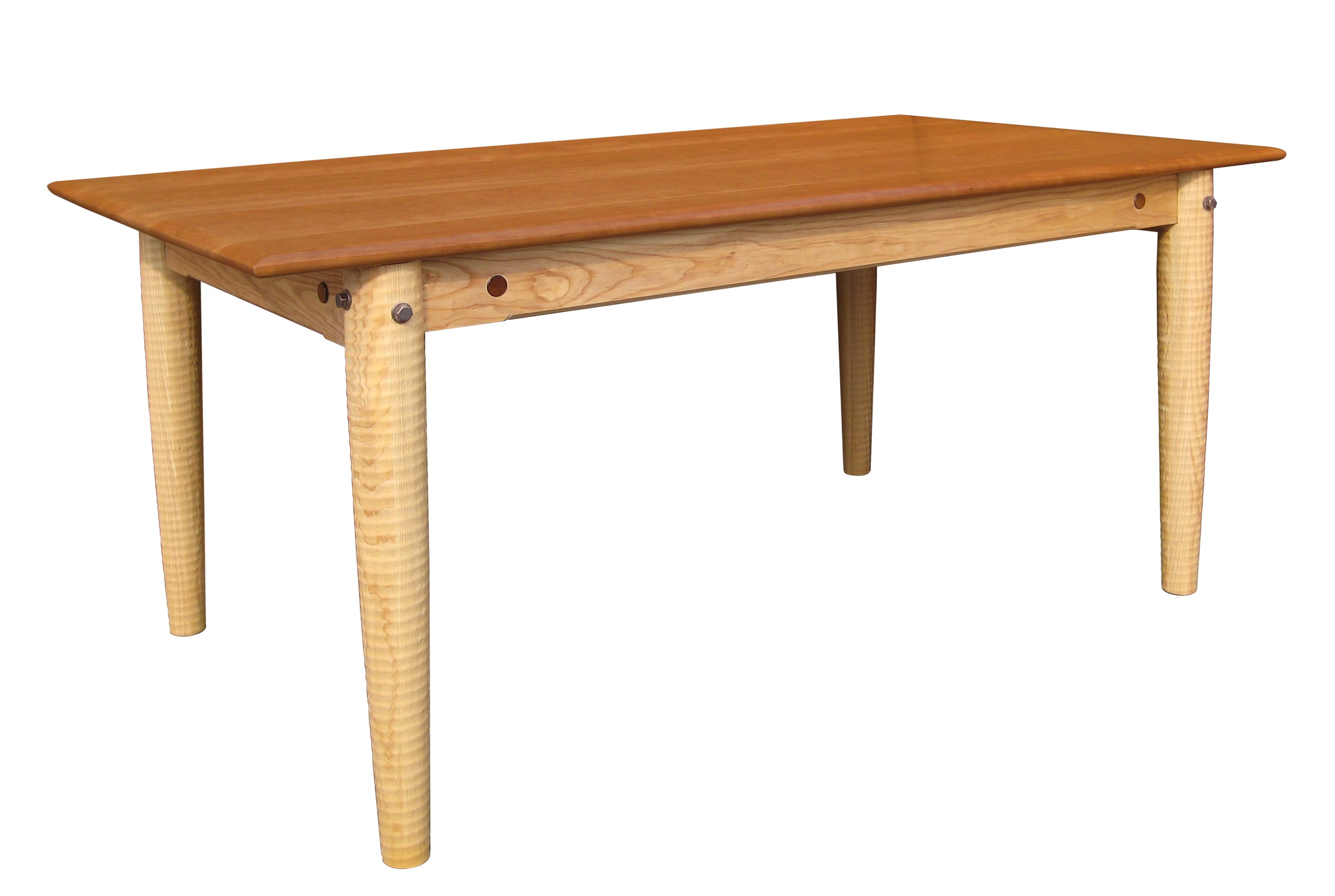 A handcrafted solid cherry and curly maple farm table with a warm honey-toned tabletop, tapered turned legs, and visible wood peg joinery, photographed on a white background.