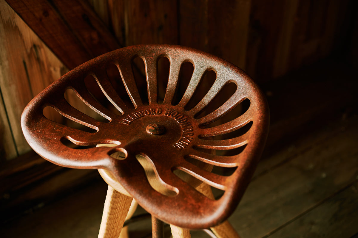 Close-up of Bradford Woodworking cast iron tractor seat, custom-cast at an Amish foundry in Lancaster County PA